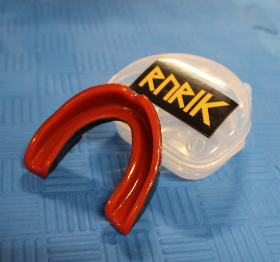 Rurik hammassuojat säilytyskotelolla puna-mustat tyylikkäät hammassuojat ylhäältä kuvattuna. Kotelon muoto ja logo saattaa vaihdella