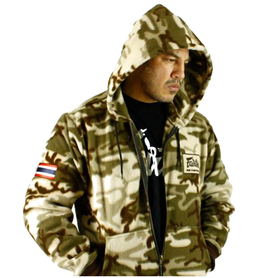Vetoketjullisessa Fairtex-hupparissa on Thaimaan lippu ommeltuna oikeassa käsivarressa ja "Be Inspired Fairtex" -merkki vasemmassa rinnassa. "Muay Thai" teksti selässä. Fleece. Kuva mallin päällä.