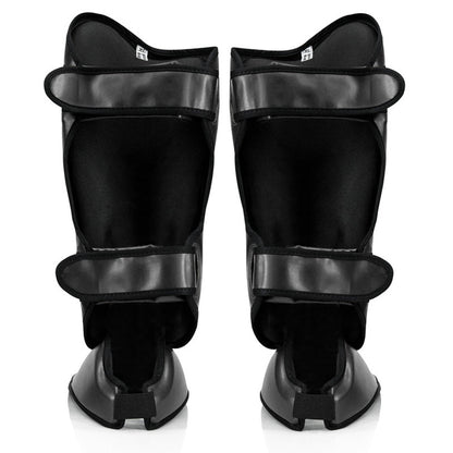 Fairtex SP9 -säärisuojat tarjoavat ylivoimaista suojaa ja mukavuutta. Fairtexin säärisuojat kuvattu takaa, mustat. Innovatiivinen uusi kiinnitys, laajennettu suoja säärille, jalkapöydälle ja varpaille.
