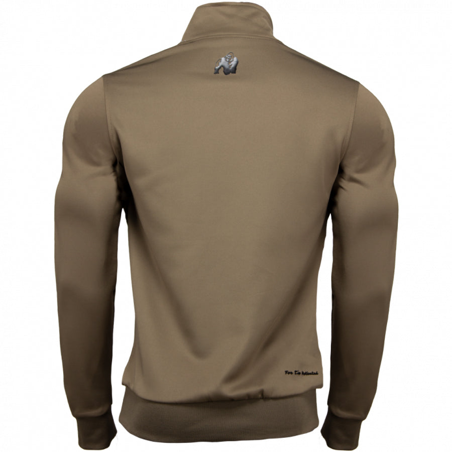 Wellington Track Jacket takki värissä khaki. Kuvattu takaa. Logo niskassa. Valkoiset raidat mustalla tekstillä hihoissa.